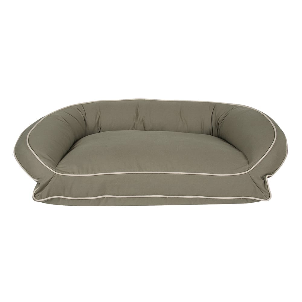 Green pet bed with white piping on a white background