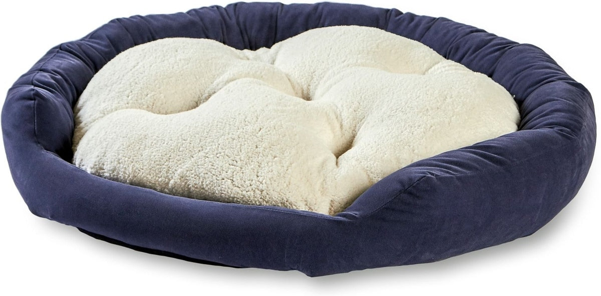 A round pet bed with a navy blue velvet-like outer wall and a tufted cream sherpa cushion inside, shown on a plain white background.