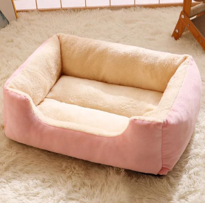 Pet bed with pink and beige sides on a fluffy white carpet