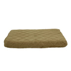 Quilted green pet bed on a beige background